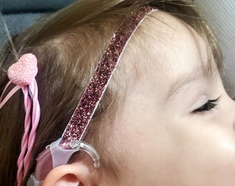 Pink Glittery hearing aid retainer,  3/4 inch width with silicone sleeves. Or cochlear headband with loop material sleeves