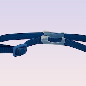 May include: A blue adjustable strap with a plastic buckle and two clear plastic loops.