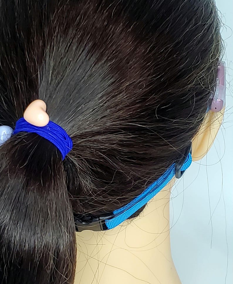 May include: A blue adjustable strap with a black buckle. The strap is designed to hold a face mask in place behind the ears.