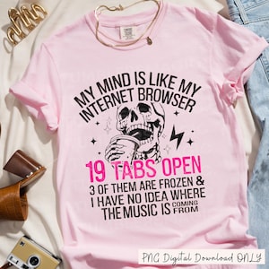 May include: Pink t-shirt with a black and white graphic of a skull holding a cup. The text on the shirt reads "My mind is like my internet browser 19 tabs open 3 of them are frozen & I have no idea where the music is coming from".
