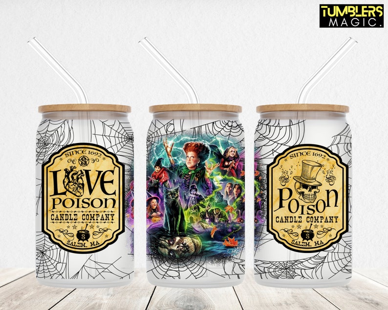 May include: Three white, stainless steel, can-shaped tumblers with black and white spiderweb designs. The tumblers have bamboo lids and clear straws. The front of each tumbler features a different design. The first tumbler has a black and white label with the text "Love Poison Candle Company" and a heart with a skull inside. The second tumbler has a colourful illustration of a witch with a black cat and other Halloween characters. The third tumbler has a black and white label with the text "Poison Candle Company" and a skull wearing a top hat.