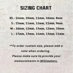 Pu&ograve; includere: Una tabella delle taglie con il titolo "SIZING CHART" in grassetto nero. La tabella elenca le taglie XS a L con le corrispondenti misure in millimetri. Un testo aggiuntivo consiglia di aggiungere una nota per le taglie personalizzate e fornire le misure in millimetri.