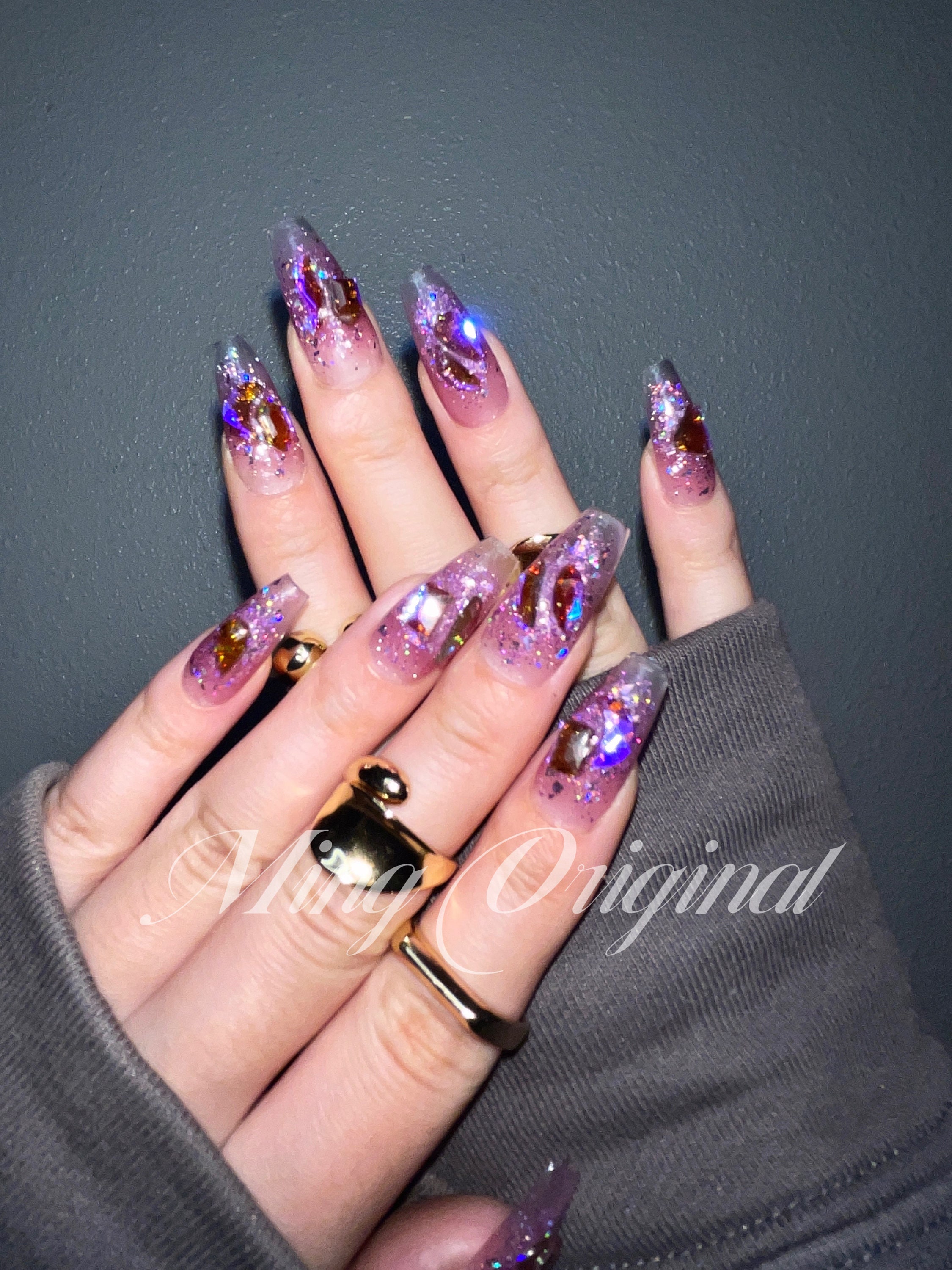 Crystal heart nail art with butterfly and glitter encapsulation. 