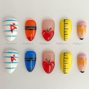 May include: A collection of ten press-on nails with school-themed designs. The designs include a red apple, a yellow ruler, a pencil, and nails resembling notebook paper and crayons. The nails are oval-shaped and have a glossy finish.