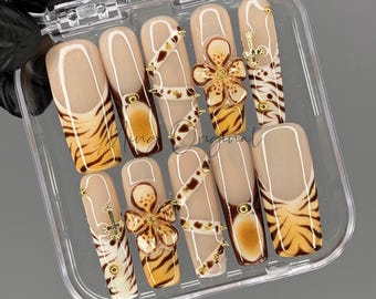 May include: A set of ten false nails with a zebra and flower design. The nails are in a clear plastic case.