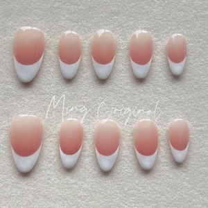 May include: Ten oval-shaped false nails with a French manicure design. The nails are a light pink color with a white tip.