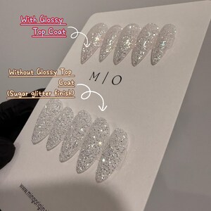 K&ouml;nnte beinhalten: Pr&auml;sentation von Kunstn&auml;geln mit Glitzer-Finish. Die obere Reihe zeigt N&auml;gel mit gl&auml;nzendem Decklack, w&auml;hrend die untere Reihe N&auml;gel mit Zuckerglitzer-Finish zeigt. Der Text lautet "With Glossy Top Coat" und "Without Glossy Top Coat (Sugar glitter finish)".