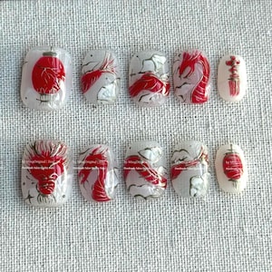 May include: A set of ten artificial nails with a white base and red and gold designs. The designs include a red lantern, koi fish, and a dragon. Some nails feature Chinese characters. The nails are handmade.