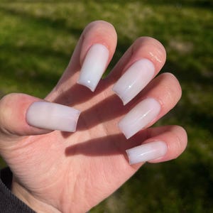Bain de lait opale, pressage fait main sur les ongles, faux ongles, ongles en gelée blanc laiteux