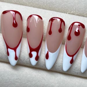 May include: Set of five fake nails with a white tip and red dripping blood design.