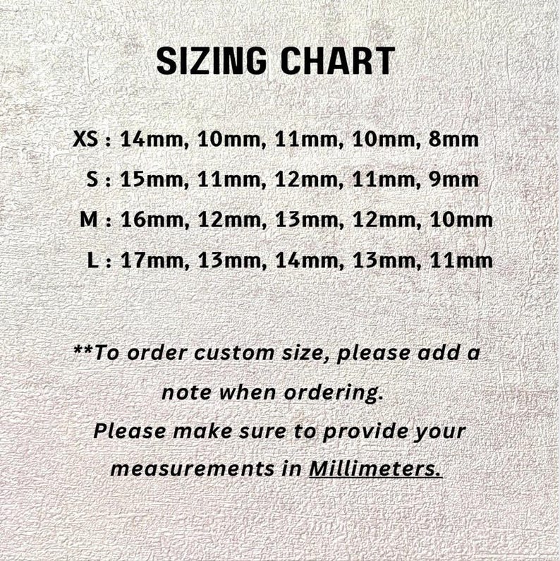 May include: A sizing chart with black text on a textured off-white background. It lists sizes XS, S, M, and L with corresponding measurements in millimeters. It includes instructions to add a note for custom sizes and provide measurements in millimeters.