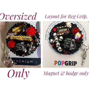 Op de afbeelding: Een zwarte en rode popgrip met een schedel- en kruisbeenderontwerp. De popgrip heeft een geel en zwart waarschuwingslint met de tekst "Let op Triggerwaarschuwing" en "Ik lees boeken met triggerwaarschuwingen". De popgrip is bevestigd aan een zilveren magneet en een badge.