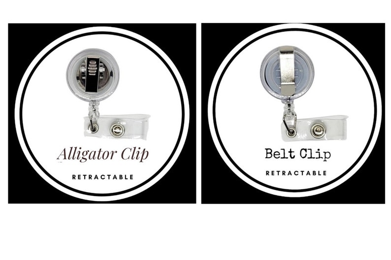 K&ouml;nnte beinhalten: Zwei ausziehbare Ausweishalter mit unterschiedlichen Clip-Stilen. Der linke Halter hat einen Alligator-Clip und der rechte Halter hat einen G&uuml;rtelclip. Beide Halter sind aus klarem Kunststoff mit einem silbernen Metallclip und einem silbernen Metallknopf.