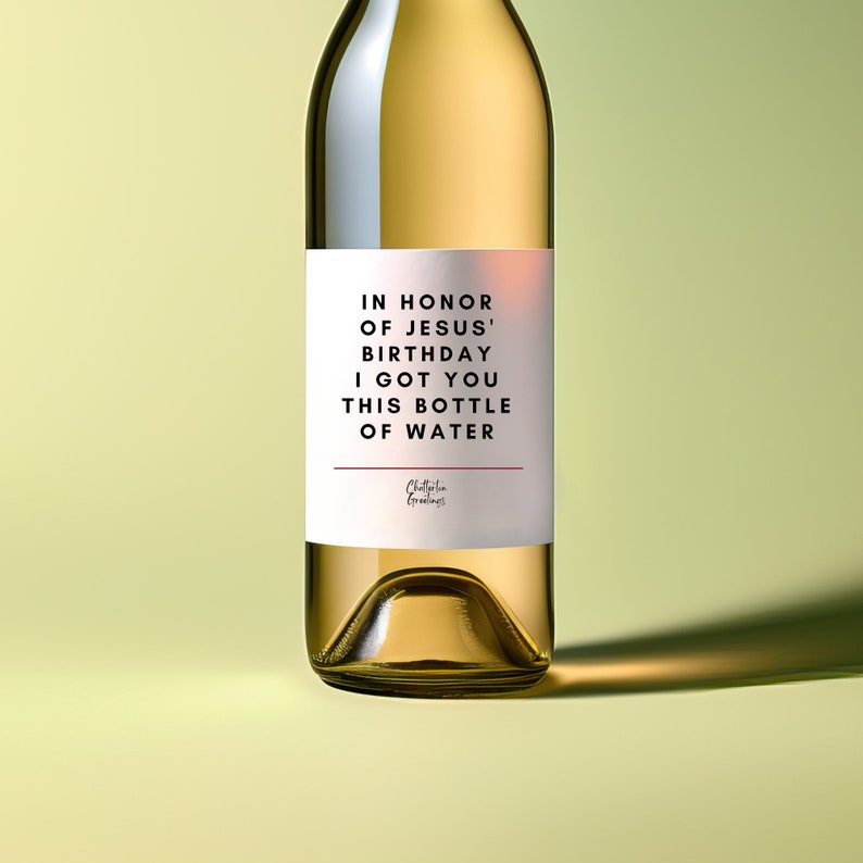 May include: A white wine bottle with a label that reads "In honour of Jesus' birthday I got you this bottle of water".
