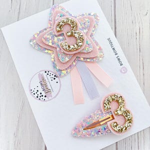 May include: A set of three ceramic mugs with a speckled, matte finish. The mugs are in shades of cream, light grey, and dark grey. Each mug has a simple, minimalist design, ideal for coffee or tea.