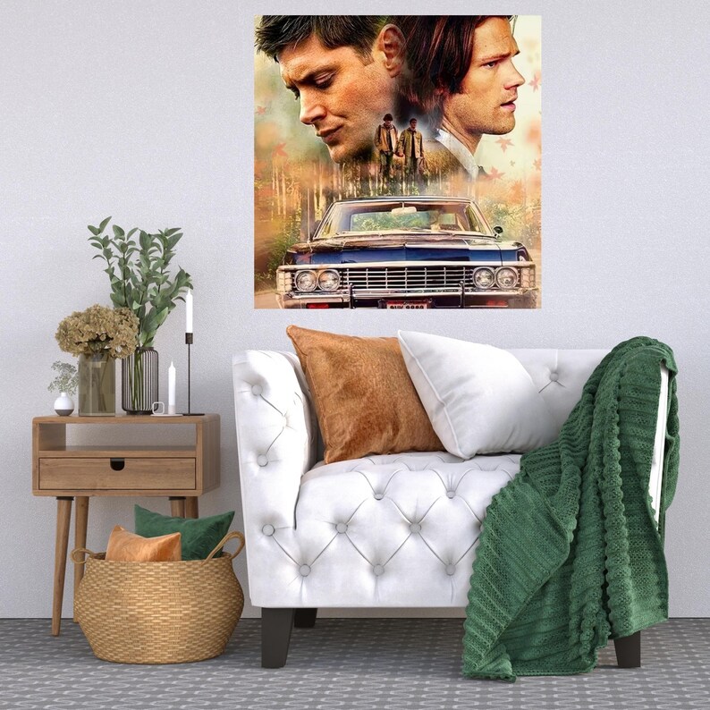 K&ouml;nnte beinhalten: Ein wei&szlig;es Sofa mit einer gr&uuml;nen Wolldecke und einem braunen Kissen. Ein Druck von zwei M&auml;nnern und einem Oldtimer h&auml;ngt an der Wand &uuml;ber dem Sofa.