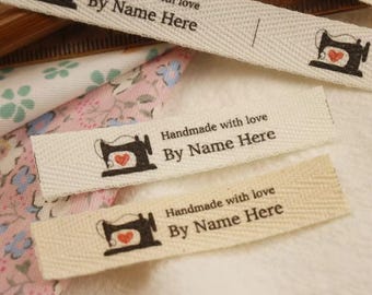 Könnte beinhalten: Drei weiße Stoff-Etiketten mit schwarzem Text und einer Nähmaschinengrafik. Der Text auf den Etiketten lautet "Handmade with love By Name Here".