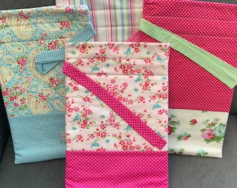 Puede incluir: Cuatro bolsas de regalo de tela con diferentes patrones. Las bolsas son todas rosas, azules y blancas con diseños florales y de lunares.