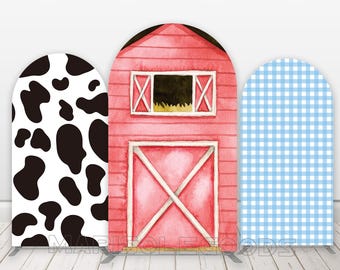 May include: Three backdrop panels for a photo booth. The panels are made of cardboard and feature a red barn, a black and white cow print, and a blue and white gingham pattern.  The panels are designed for a farm-themed party.