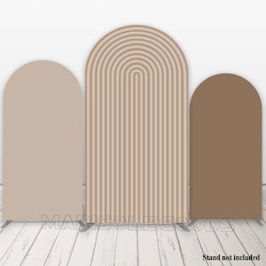 Peut inclure: Trois toiles de fond en forme d'arche pour la photographie. La toile de fond à gauche est de couleur brun clair unie. La toile de fond au centre est un motif rayé brun clair et crème. La toile de fond à droite est de couleur brun unie.