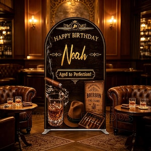 May include: An arched birthday backdrop sign featuring a dark wood texture, gold text reading Happy Birthday Noah and Aged to Perfection!, a glass of whiskey with ice, a fedora hat, and a wooden box filled with cigars on a stand.