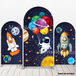 Op de afbeelding: Drie boogvormige achtergronden voor een ruimtethemafeest. De middelste achtergrond toont een astronaut die een bos kleurrijke ballonnen vasthoudt die de vorm van planeten hebben. De linker achtergrond toont een raket en een planeet. De rechter achtergrond toont een raket en een planeet.