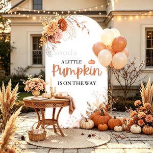 Könnte beinhalten: Ein bogenförmiger Hintergrund mit dem Text A LITTLE PUMPKIN IS ON THE WAY, verziert mit orangefarbenen und cremefarbenen Blumen, Luftballons und Kürbissen. Ein Korbtisch steht davor mit einem Blumenarrangement und einem geflochtenen Korb.