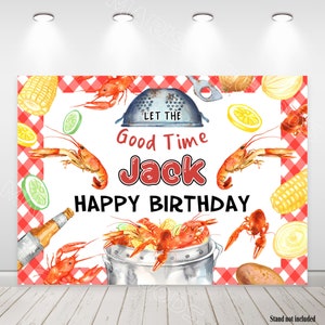 Puede incluir: Un fondo blanco con un patrón de cuadros rojos y blancos. El texto "Let the Good Time Jack Happy Birthday" está escrito en rojo y negro. La imagen presenta una ilustración de acuarela de cangrejos de río, maíz en la mazorca, limones, cebollas y una olla de cangrejos de río.