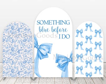 May include: Three blue and white archway backdrop panels for a wedding or bridal shower. The center panel features the text "Something blue before I do". The left panel has a blue and white floral pattern. The right panel has a repeating pattern of blue bows.