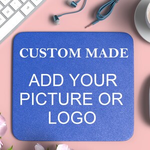 May include: A blue mouse mat with the text "CUSTOM MADE ADD YOUR PICTURE OR LOGO" in white.