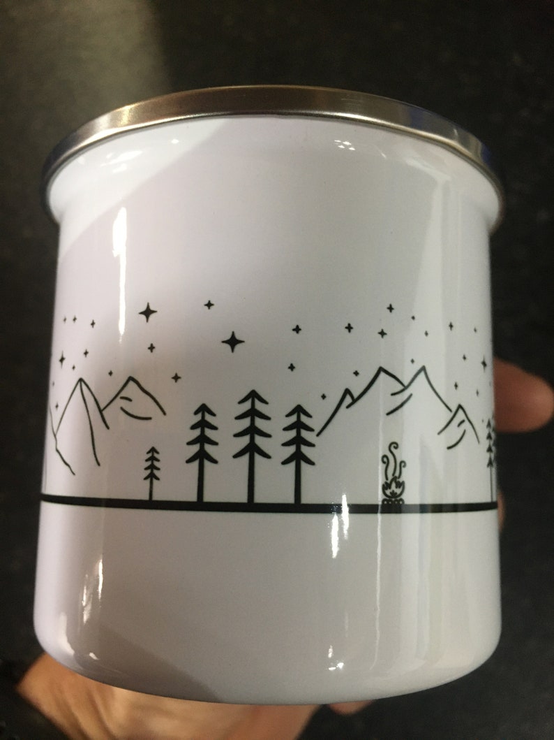 Pu&ograve; includere: Tazza da campeggio in smalto bianco con un design a silhouette nera di montagne, alberi e un fal&ograve; sotto un cielo stellato.