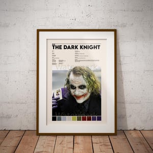 Könnte beinhalten: Ein Poster mit einer Nahaufnahme des Jokers aus dem Film "The Dark Knight". Er hält eine Spielkarte mit einem Joker darauf und hat ein unheilvolles Lächeln im Gesicht. Das Poster enthält auch eine Farbpalette mit verschiedenen Grautönen, Grün, Braun, Rot, Lila und Schwarz.