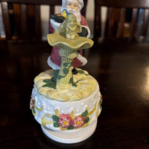Vintage Santa Claus wind-up music box, rotates, plays “Santa Claus is Coming To Town.”