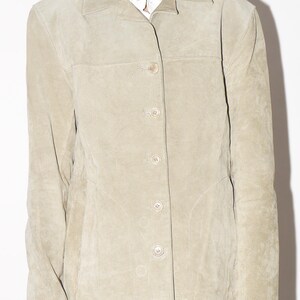 Pu&ograve; includere: Giacca in pelle scamosciata beige chiaro con collo e chiusura con bottoni. La giacca ha un design classico con una vestibilit&agrave; sartoriale, chiusura con bottoni e una finitura sottile e strutturata. La giacca &egrave; di colore neutro, adatta a vari outfit.