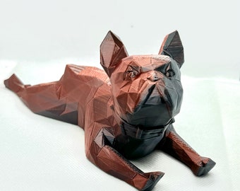 May include: A 3D printed figurine of a French bulldog lying down. The figurine is made of a brown and black plastic and has a geometric design.