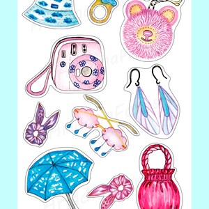 以下が含まれることがあります： 水彩イラスト。雲模様の青いバケットハット、ピンクのインスタントカメラ、ふわふわのピンクのクマのキーホルダー、青と紫のイヤリングなど、さまざまなアクセサリーが描かれています。 その他、指輪、ピンクのバッグ、青い傘などがあります。