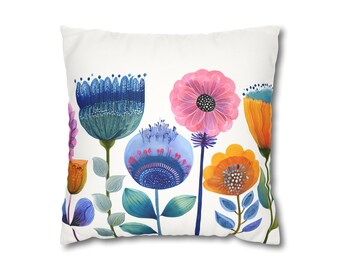 Puede incluir: Cojín cuadrado blanco con un diseño floral colorido. Las flores son en tonos de azul, rosa, naranja y morado, con hojas verdes. El cojín tiene una estética limpia y moderna.