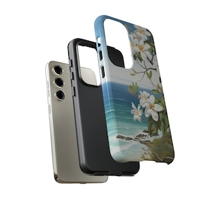 Pu&ograve; includere: Una custodia per telefono nera con un design floreale. La custodia presenta un fiore bianco con un centro giallo e foglie verdi. Lo sfondo &egrave; un dipinto ad acquerello blu e bianco di una scena di spiaggia.