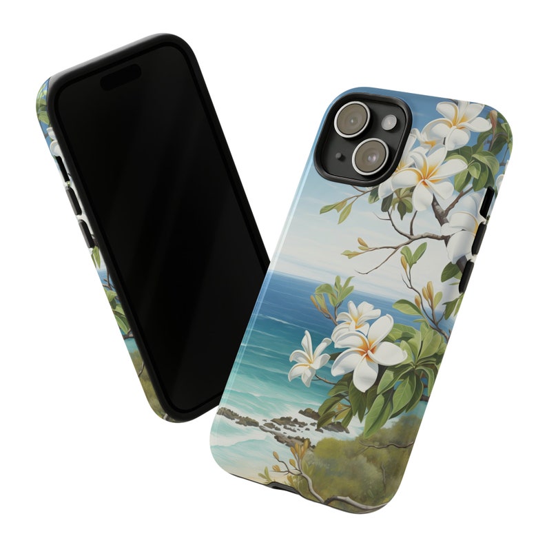 Pu&ograve; includere: Una custodia per telefono con una scena di spiaggia tropicale con fiori bianchi, acqua blu e fogliame verde. La custodia ha un bordo nero e un ritaglio per la fotocamera.