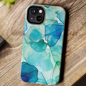 May include: A clear phone case with a blue and green abstract design. The case has a camera cutout for a dual-lens camera.