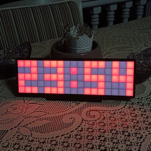 May include: A black rectangular LED sign with a red and white pixelated display showing the word "YEAH".