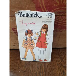 Puede incluir: Patrón de costura vintage para un vestido de niña, Butterick número 4929, talla 2, $ 1,25, Canadá $ 1,35. El patrón presenta a dos niñas con vestidos con bolsillos y una jaula para pájaros.