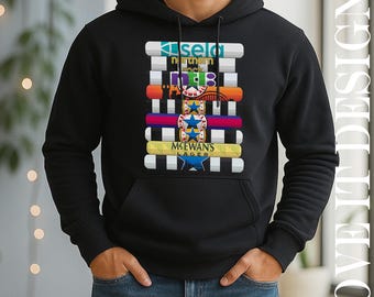 May include: Black hooded sweatshirt with a colorful graphic design. The design includes text and various shapes in white, blue, orange, and yellow. The text includes the words "sela", "northern", "MCEWAN'S LAGER", and other text.