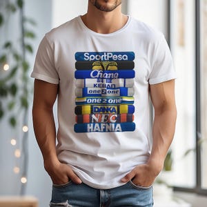 May include: White t-shirt with a graphic of stacked, colourful banners. Each banner has a different name, such as "SportPesa," "Chang," and "Hafnia." The design is centrally placed on the shirt.