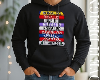 May include: Black hooded sweatshirt with a stacked design featuring the name "RONALDO" in various colors. The design includes a yellow, red, purple, white, blue, and green color scheme. The sweatshirt has a front pocket and a drawstring hood.