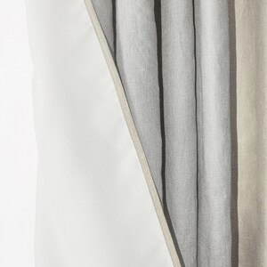 May include: Close-up of a set of linen curtains with a white lining. The curtains are a light gray color and have a subtle texture.