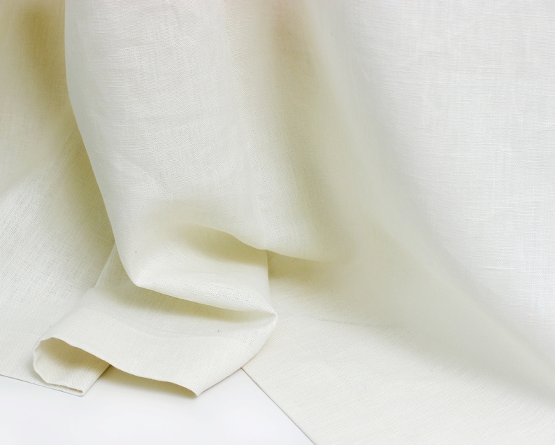 May include: A close-up of a white linen fabric, showing its texture and drape.