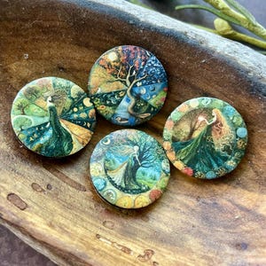 May include: Four round, decorative wooden pieces with colorful, detailed illustrations. One features a peacock, another a tree with seasonal elements, and two depict figures in flowing gowns. The pieces are set in a rustic wooden bowl.