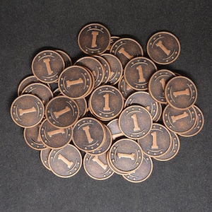 Peut inclure: Un tas de jetons de couleur cuivre avec le numéro "1" imprimé sur chacun. Les jetons sont disposés de manière aléatoire.