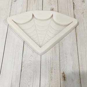 May include: White silicone mold shaped like a spider web. The mold is designed to create a decorative piece for crafts or baking.